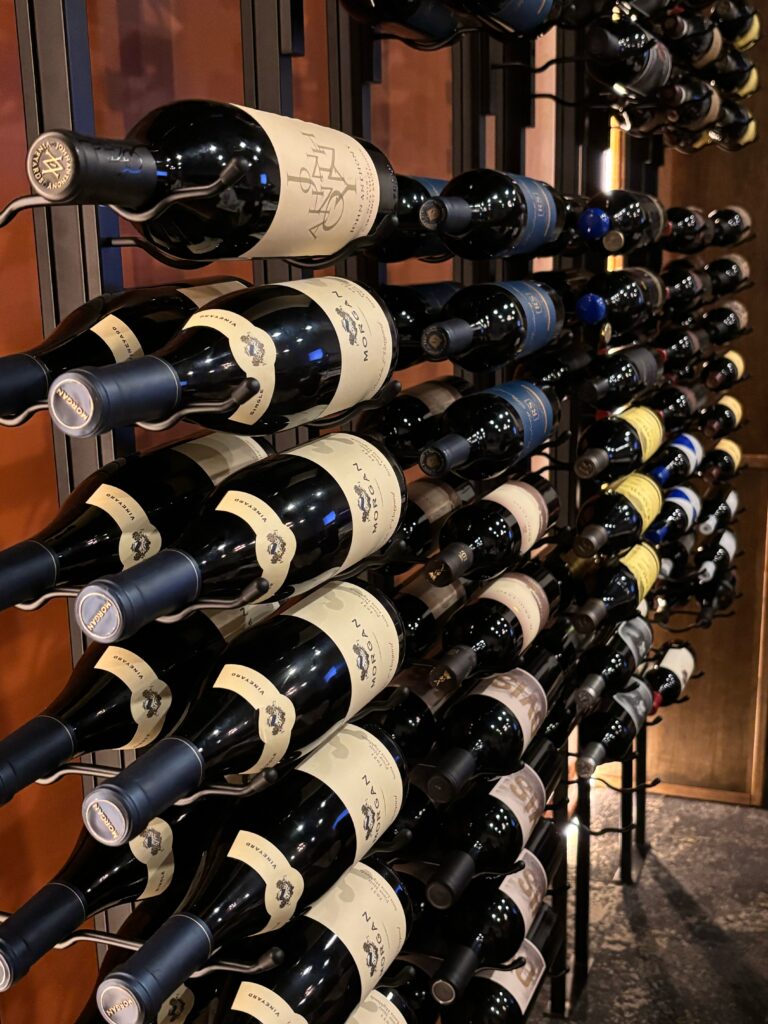 Wine bottles hanging on a rack during a corporate dinner event.